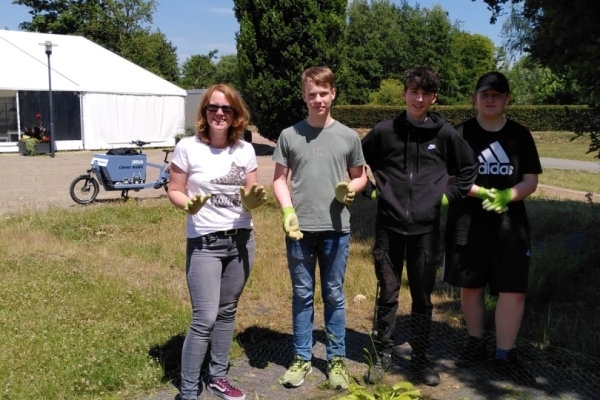 Bild: 4 Personen vor einem Blumenbeet