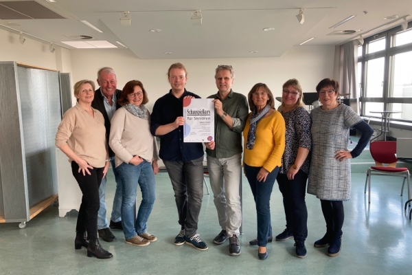 Schauspielkurs für Senioren Bild: Eine Gruppe von Frauen und Männern hält ein Plakat mit der Ankündigung des Kurse in die Kamera.