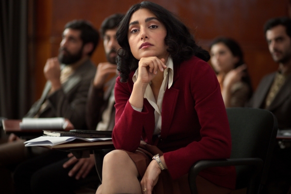 Bild: Ein Frau sitzt auf einen Stuhl und schaut in die Kamera