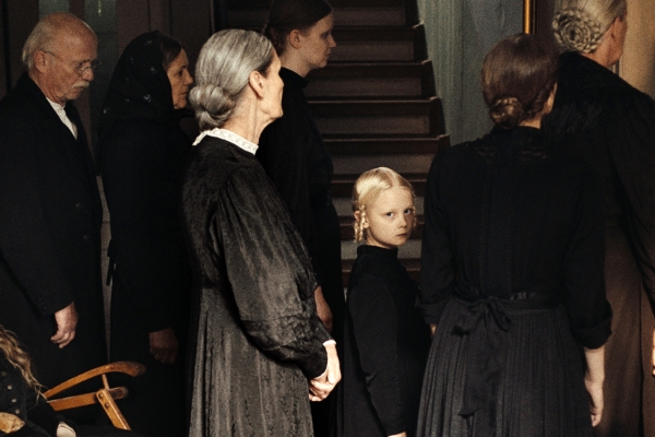 Kino: In die Sonne schauen Bild: Mehrere Frauen unterschiedlichen Alters, ein Mann und ein Kind stehen in einem Hausflur vor einer Treppe.