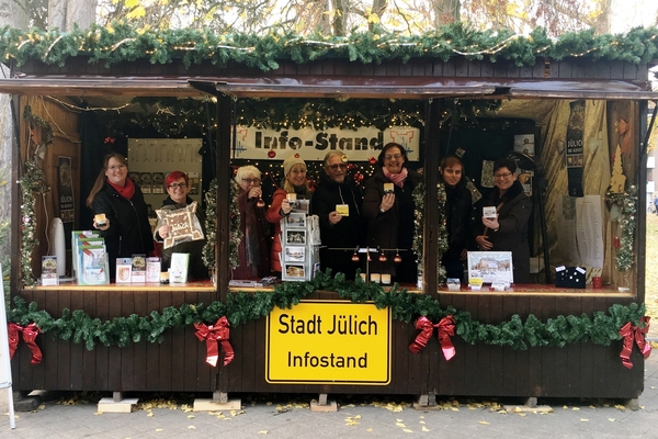 Bild: Das Team der Tourist-Info prÃ¤sentiert die Souvenirs der Stadt JÃ¼lich, die auf dem Weihnachtsmarkt erhÃ¤ltlich sind. Foto: Stadt JÃ¼lich/Stein