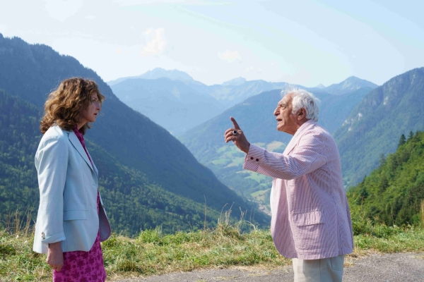 Bild: Eine Frau (link) und ein Mann stehen sich auf einer Bergstraße gegenüber und reden miteinander. 